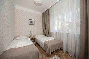 2 camas en una habitación con ventana en Hotel Polonia en Rzeszów