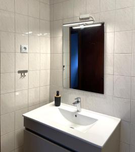 a white bathroom with a sink and a mirror at Casa da Laurinha in Arcos de Valdevez