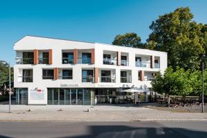 a white building on the side of a street at Radlon Fahrrad-Komfort-Hotel in Waren