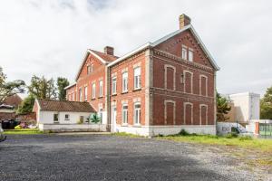 an old brick building on the side of a street at Le Larsen in Liévin