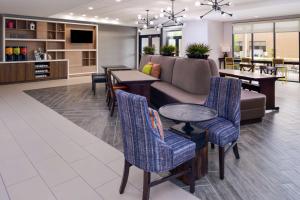 a lobby with a couch and a table and chairs at Home2 Suites By Hilton Merrillville in Merrillville