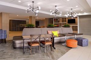 a dining room with a couch and a table and chairs at Home2 Suites By Hilton Merrillville in Merrillville