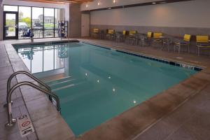 ein Pool in einem Hotelzimmer mit Stühlen drum herum in der Unterkunft Home2 Suites By Hilton Merrillville in Merrillville