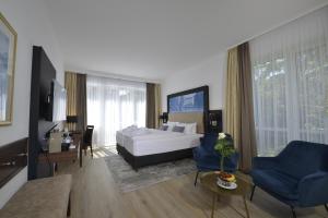1 dormitorio con 1 cama y sala de estar en Hotel Caroline Mathilde en Celle
