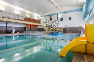 une piscine vide avec un toboggan jaune dedans dans l'établissement Comfort Inn & Suites Mitchell I-90, à Mitchell