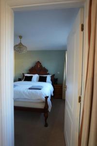 1 dormitorio con cama blanca y lámpara de araña en Cosy Stirling 3-bedroom Home, en Stirling