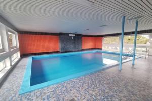 a large swimming pool in a room with orange walls at Appartementvermittlung Mehr als Meer Objekt 36 in Niendorf