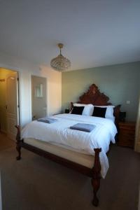 a bedroom with a large bed with white sheets at Cosy Stirling 3-bedroom Home in Stirling