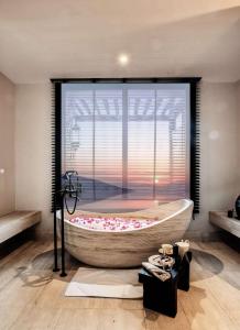 a bath tub in a room with a large window at Alila Jabal Akhdar in Al Khuţaym