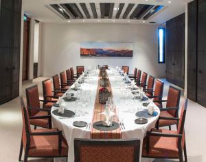 uma longa sala de jantar com uma longa mesa e cadeiras em Alila Jabal Akhdar em Al Khuţaym