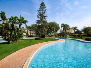 十月六日城的住宿－Mövenpick Hotel Cairo - Media City，一座树木繁茂的庭院内的游泳池