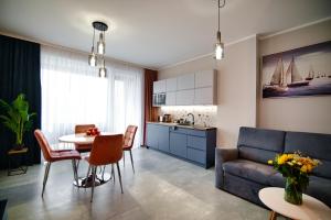ザジェチェにあるLaguna Beskidów Resort - Apartament A59のソファとテーブルとキッチンのあるリビングルーム