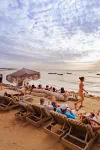 un grupo de personas tumbadas en sillas en una playa en Casa de Areia, en Jericoacoara