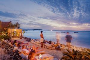 grupa ludzi siedzących na leżakach na plaży w obiekcie Casa de Areia w mieście Jericoacoara