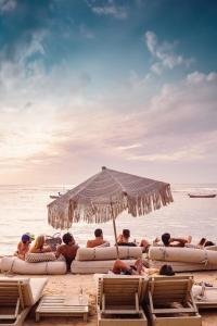 um grupo de pessoas deitadas na praia sob um guarda-sol em Casa de Areia em Jericoacoara