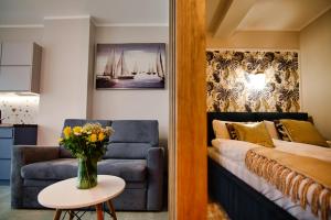 ザジェチェにあるLaguna Beskidów Resort - Apartament A59のソファとベッドのあるリビングルーム +17枚の写真