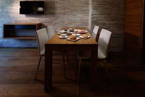 een houten tafel met stoelen en eten erop bij Sottovento Luxury Hospitality in Bormio