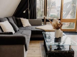 a living room with a couch and a glass table at Holiday Home Hexenhaus im Harz by Interhome in Clausthal-Zellerfeld
