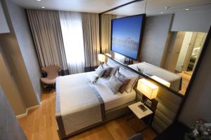 ein Hotelzimmer mit einem Bett und einem großen Spiegel in der Unterkunft Luxury Rooms Fortuna in Split