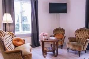 a living room with chairs and a table and a tv at Saarijärven Ruustinna Oy in Saarijärvi