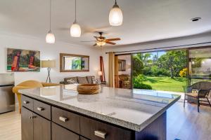 a kitchen with a counter top and a living room at Koa Resort 1b in Kihei