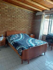 uma cama num quarto com uma parede de tijolos em Doslilas em Guaymallén