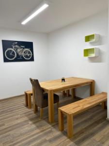 ein Esszimmer mit einem Holztisch und einem Fahrrad an der Wand in der Unterkunft Boardinghouse am Steinkläffle in Friolzheim