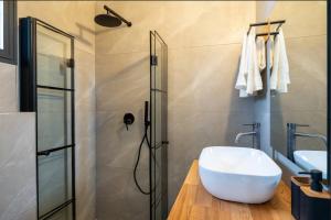 een badkamer met een witte wastafel en een douche bij eve's room in Haifa