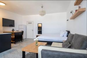 een woonkamer met een bank en een bed bij eve's room in Haifa