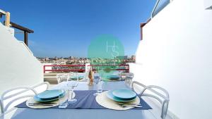 uma mesa com pratos e copos numa varanda em Penthouse Triplex com Jacuzzi T3 HsR Vilamarina em Quarteira