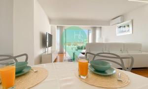 uma mesa com dois pratos e dois copos de sumo de laranja em Penthouse Triplex com Jacuzzi T3 HsR Vilamarina em Quarteira