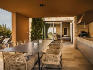 a dining room with a table and chairs on a patio at Villa Vigneto by Interhome in Brtonigla