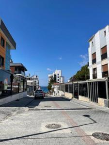 een auto die door een straat naast gebouwen rijdt bij LOTUS Apart in Kuşadası