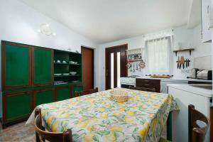 a kitchen with a table and green cabinets at Apartment in Mugeba/Istrien 27611 in Mugeba