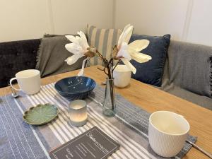 un tavolo con un vaso con fiori bianchi di Holiday Home Tiny Haus Soul & Forest by Interhome a Wemding Altre 19 foto