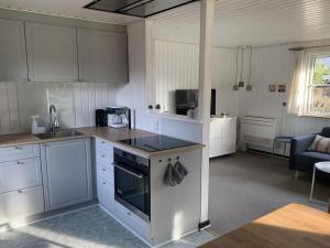 a kitchen with white cabinets and a stove top oven at Holiday Home Domnika - 200m from the sea in SE Jutland by Interhome in Binderup Strand