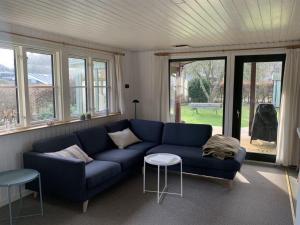 sala de estar con sofá azul y algunas ventanas en Holiday Home Domnika - 200m from the sea in SE Jutland by Interhome, en Binderup Strand