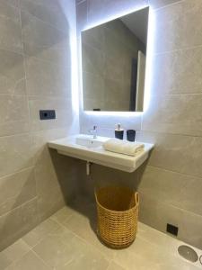 Apartamento en Casco Vello Vigo في فيغو: حمام مع حوض ومرآة وسلة