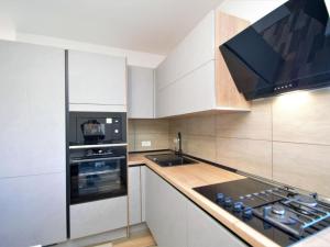 een keuken met witte kasten en een fornuis met oven bij Holiday Home Aurora by Interhome in Skradin