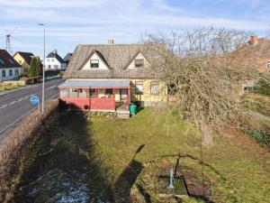 a house on the side of a hill with a tree at Apartment Thera - 5km from the sea in Bornholm by Interhome in Gudhjem