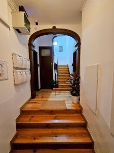 łuk prowadzący do korytarza z drewnianą podłogą w obiekcie Vila Queirós - Cozy&Sweet w Lizbonie