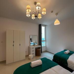 a bedroom with two beds and a desk at Sky-high Villa فيلا عنان السماء in Jeddah