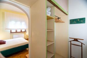 a room with a bed and a closet with shelves at sunny courtyard in Piombino