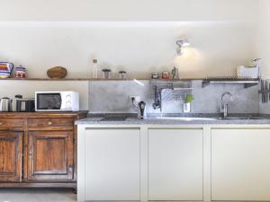 una cucina con armadi bianchi e lavandino di Apartment Noce by Interhome a Marciana