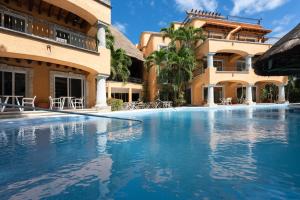 uma piscina em frente a um edifício em Eurostars Hacienda Vista Real em Playa del Carmen