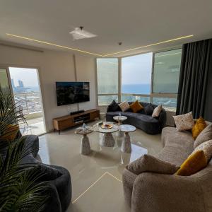 a living room with couches and a flat screen tv at Sky-high Villa فيلا عنان السماء in Jeddah