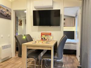 een eetkamer met een tafel met stoelen en een tv bij Holiday Home Seeblick by Interhome in Wemding