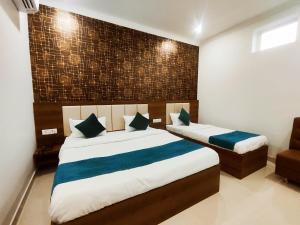 a bedroom with two beds and a brick wall at HOTEL JVS PALACE in Gorakhpur