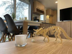 een houten dinosaurus op een tafel met een glas melk bij Holiday Home Tiny Haus SMALI by Interhome in Riedenburg