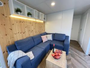 a living room with a blue couch and a table at Holiday Home Tiny Haus Altmühlblick II by Interhome in Riedenburg